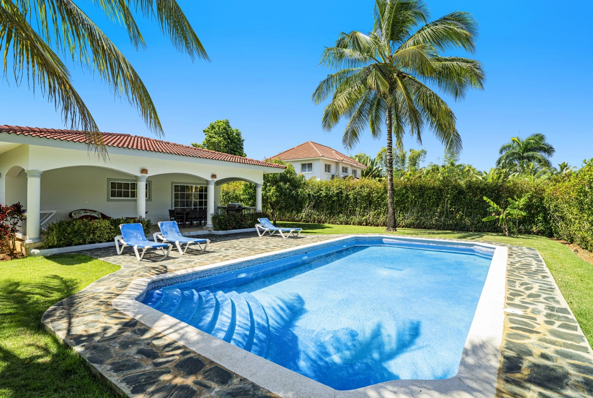 buyDRproperty Oversized villa in Sosua with a pool, lounge chairs, and palm trees. Sosua Real Estate
