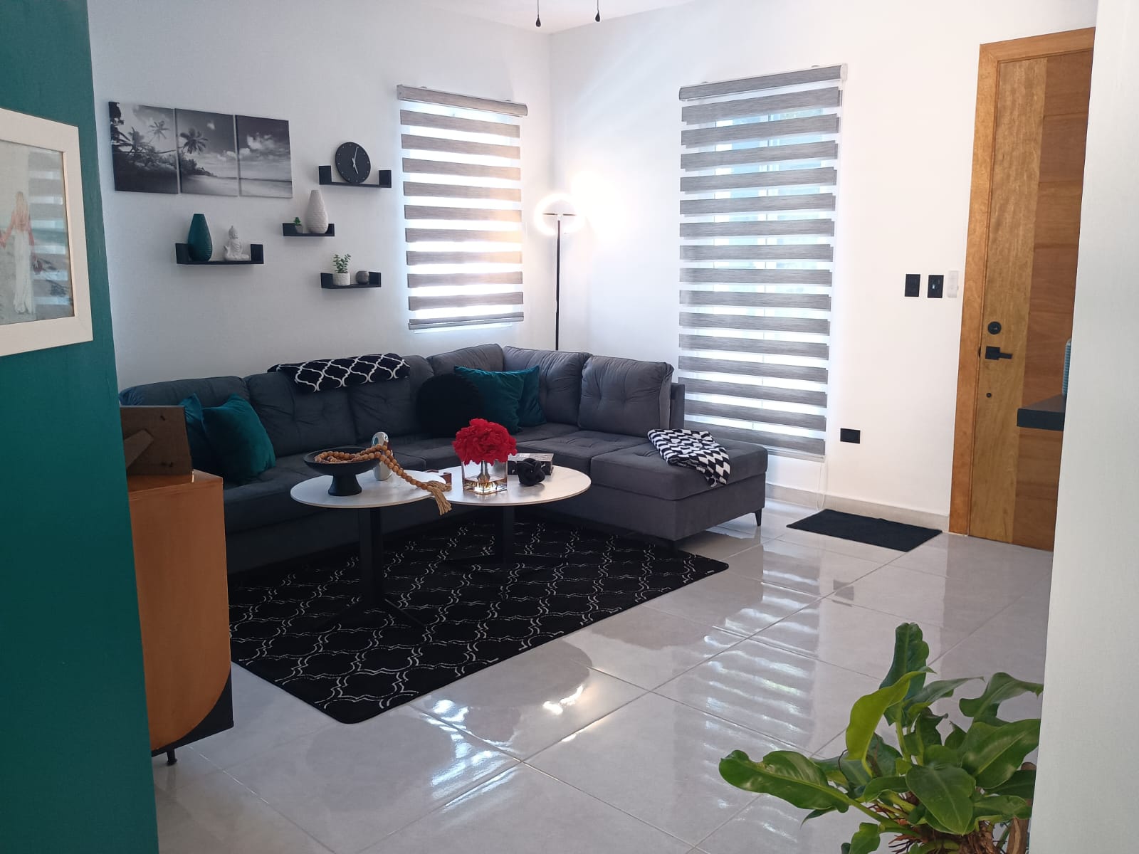 buyDRproperty Modern living room with gray sofa, black rug, and white walls. Sosua Real Estate