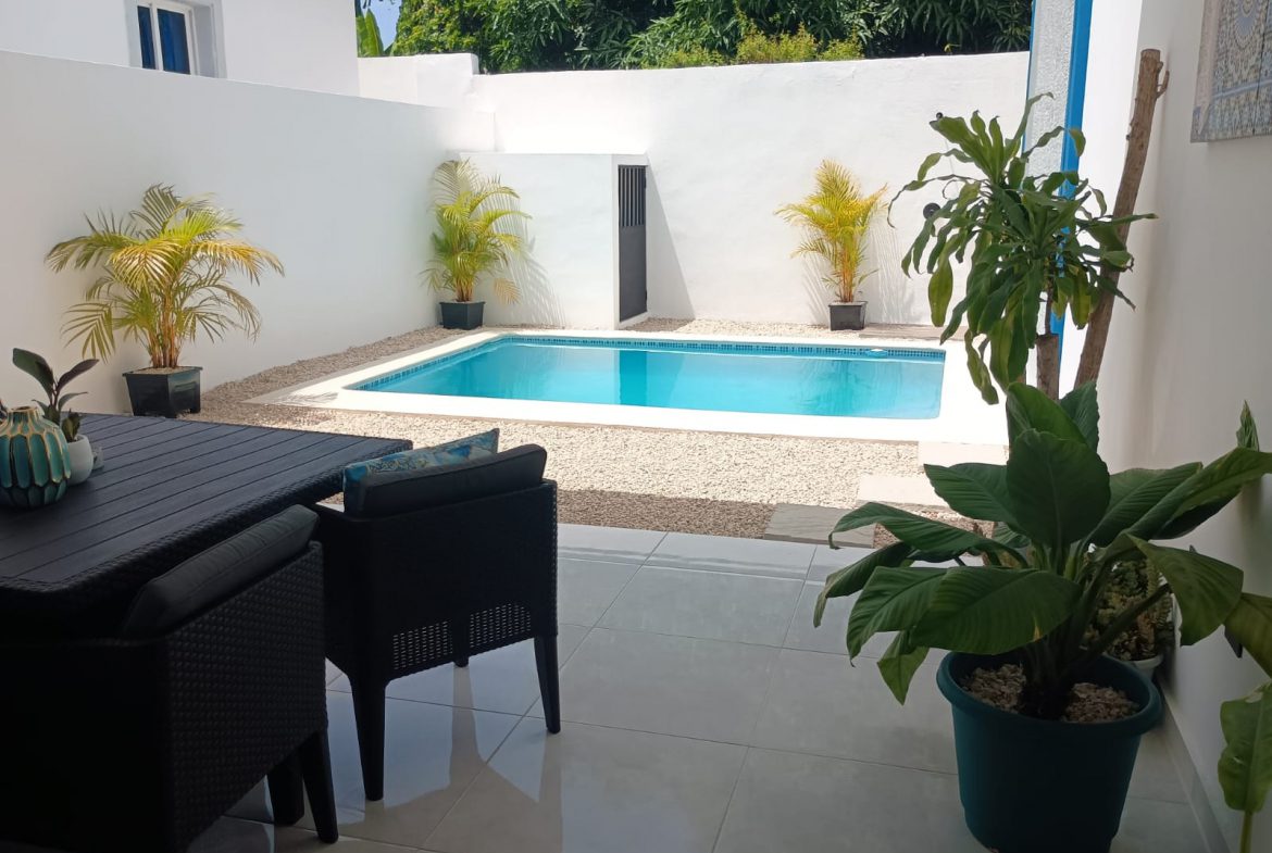 buyDRproperty Modern outdoor patio with swimming pool and plants. Sosua Real Estate