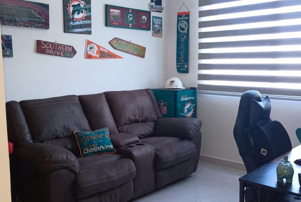 buyDRproperty Modern room with Miami Dolphins decor including street signs and couch. Sosua Real Estate