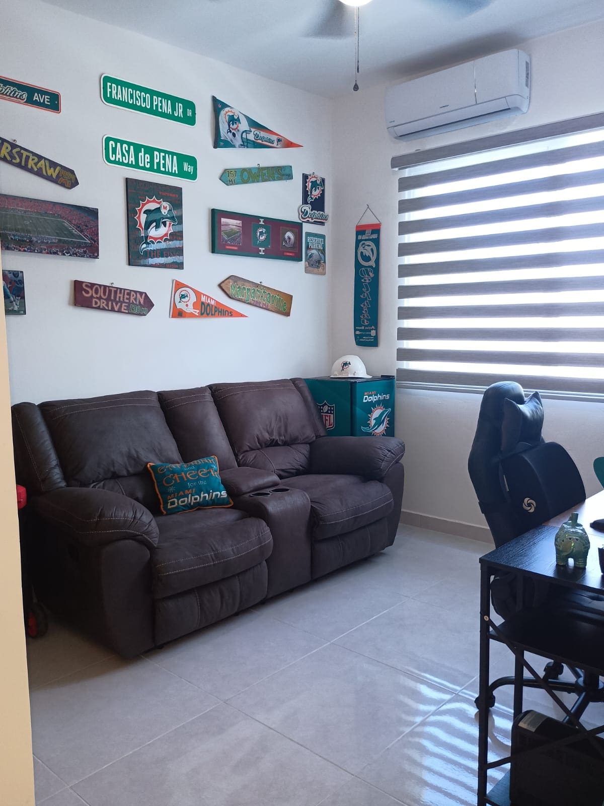buyDRproperty Modern room with Miami Dolphins decor including street signs and couch. Sosua Real Estate