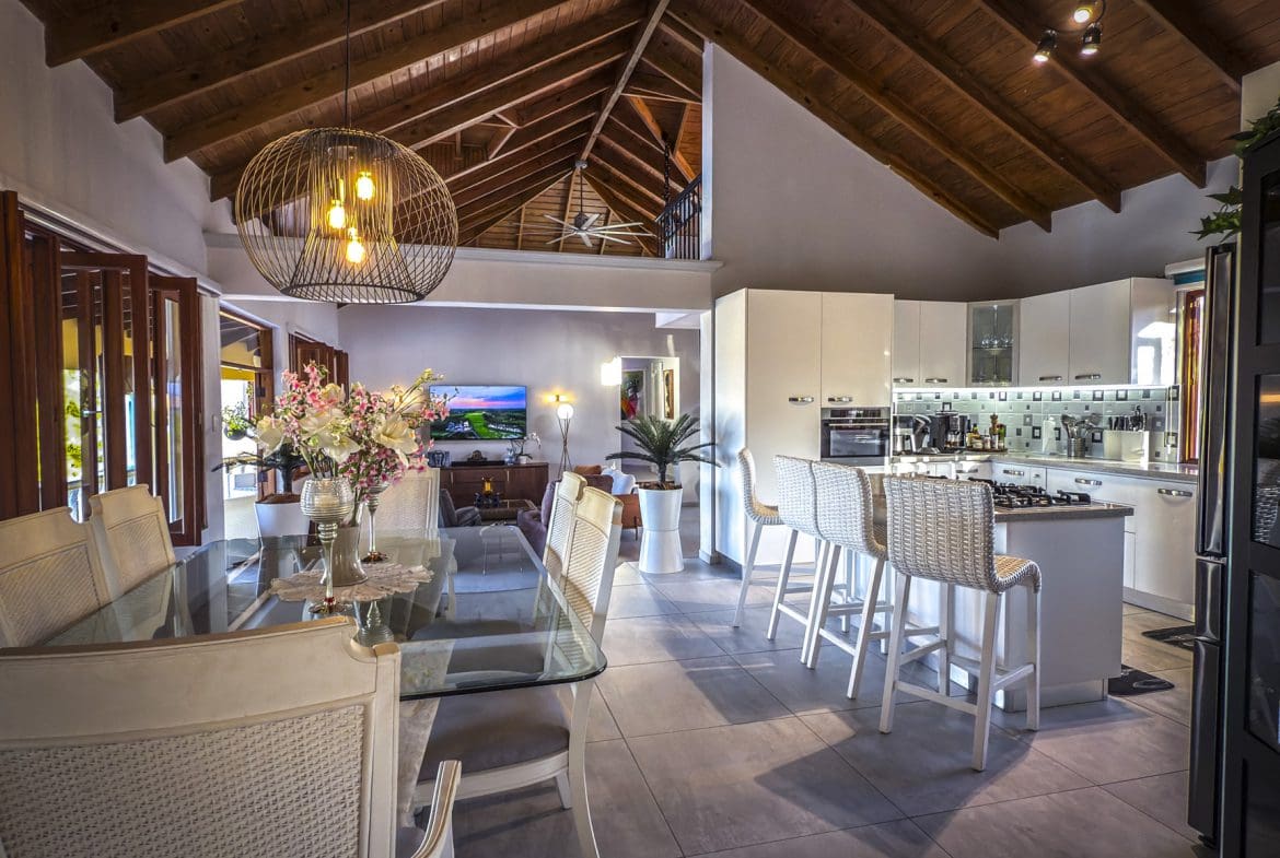 buyDRproperty Luxury villa interior with ocean views, featuring a dining area and modern kitchen. Sosua Real Estate