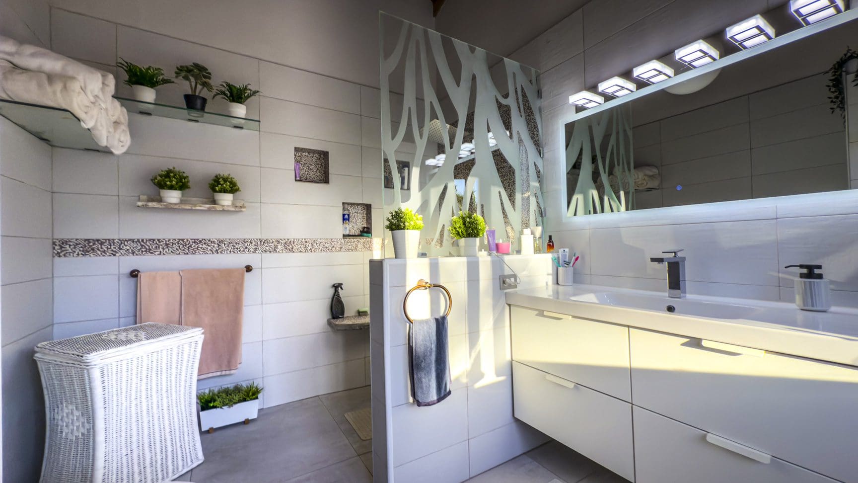 buyDRproperty Modern bathroom with ocean view villa style, white tiles, and decorative plants. Sosua Real Estate