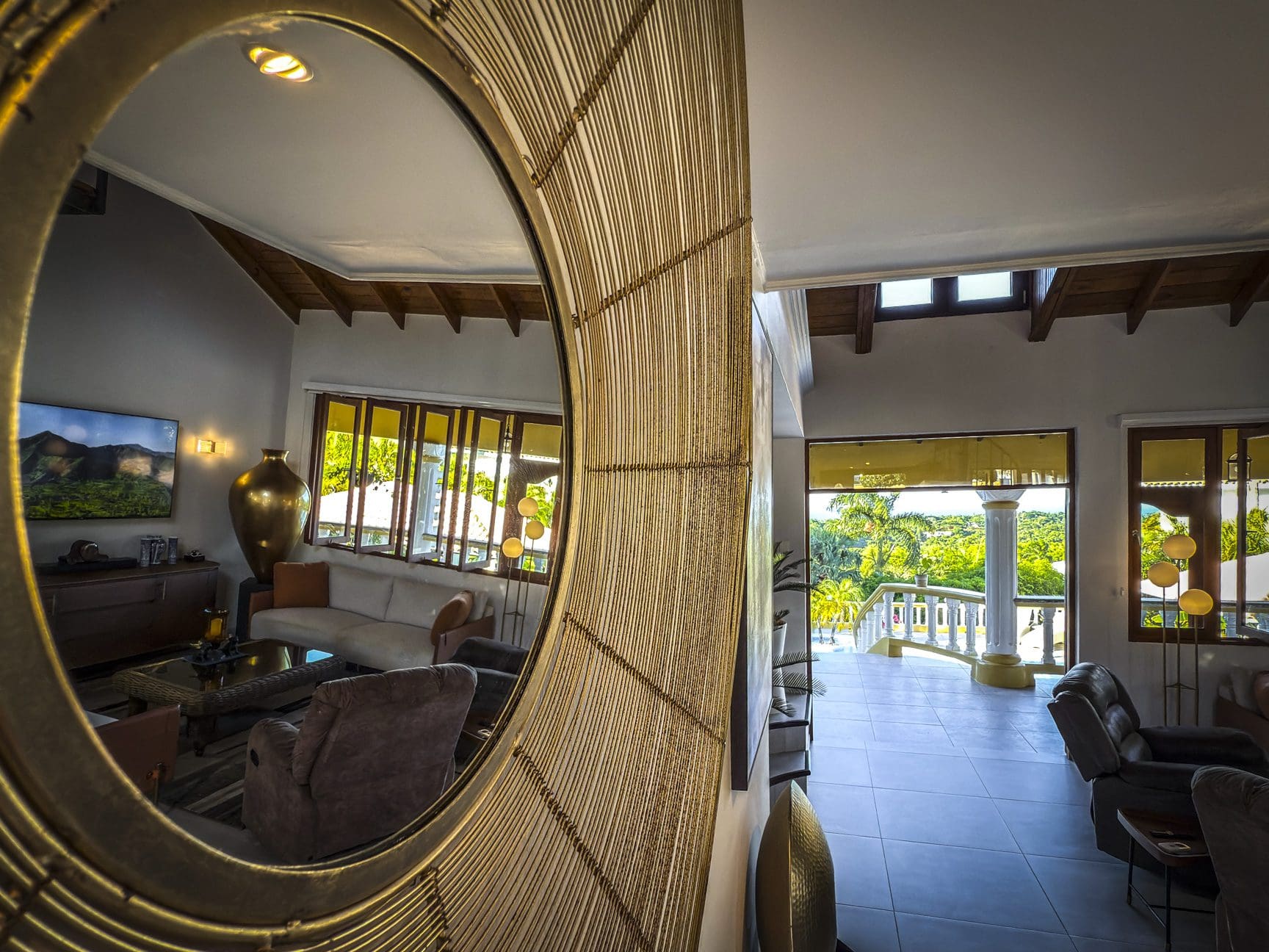 buyDRproperty Luxury villa interior reflected in a mirror showing living room with ocean views. Villa For Sale. Sosua Real Estate