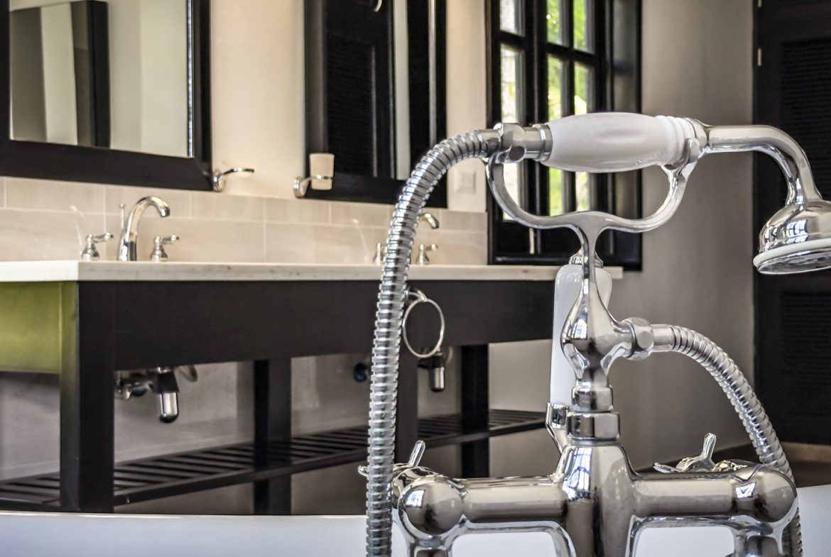 buyDRproperty Chrome shower fixture in a luxury bathroom with marble vanity and clawfoot tub Sosua Real Estate