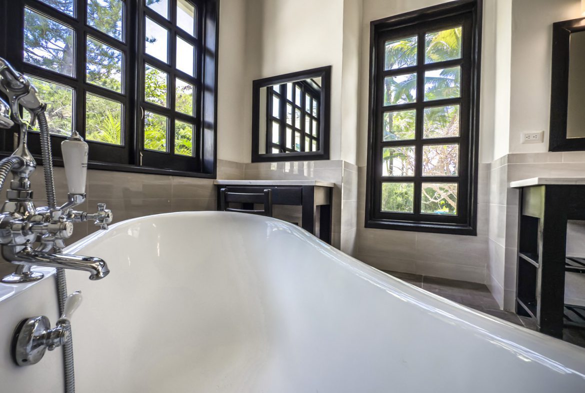 buyDRproperty Luxury bathroom with clawfoot tub, black framed windows, and spa-like ambiance. Sosua Real Estate