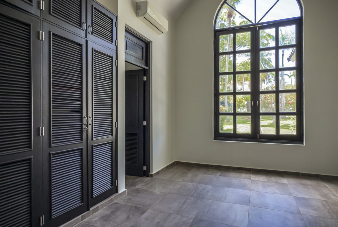 buyDRproperty Luxury home interior with black wardrobe and arched window, modern design. Sosua Real Estate