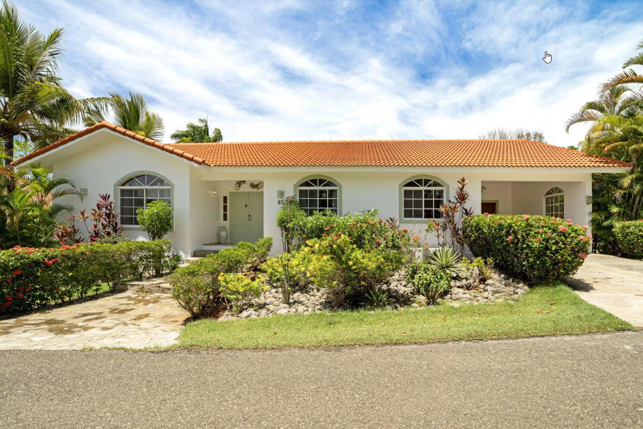 buyDRproperty Ocean View house in Residential Hispaniola, featuring lush landscaping and tile roof. Sosua Real Estate