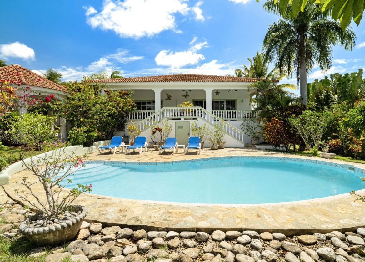 buyDRproperty Luxury ocean view villa with a pool and lounge chairs in Residential Hispaniola. Sosua Real Estate