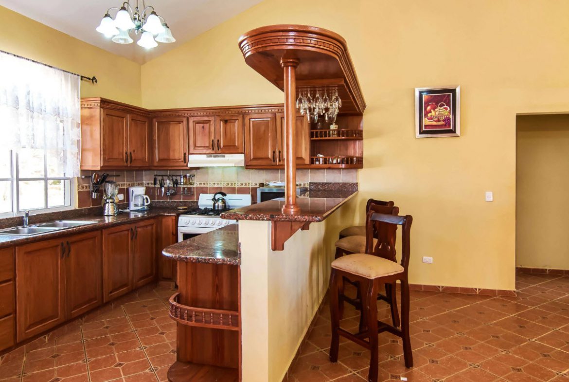 buyDRproperty Kitchen in a villa for sale at Residential Hispaniola with a bar and seating. Sosua Real Estate