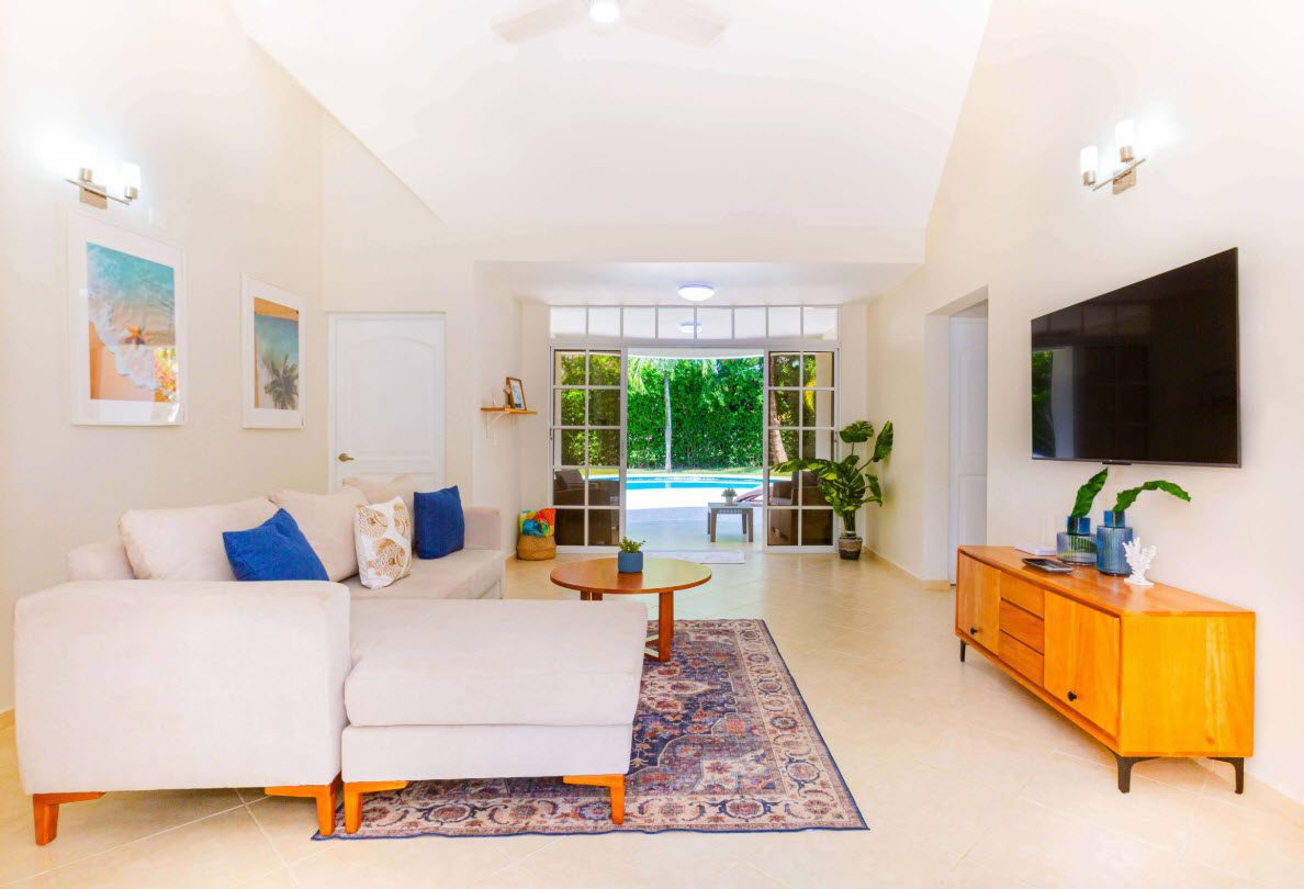 buyDRproperty Living room of a 3 BR Villa with pool in Sosúa, featuring a modern sofa, TV, and access to the pool. Sosua Real Estate