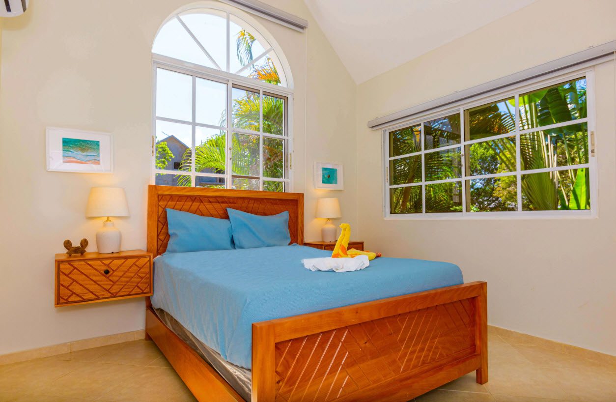 buyDRproperty Bedroom in a 3 BR Villa with blue bedding and large windows. Sosua Real Estate
