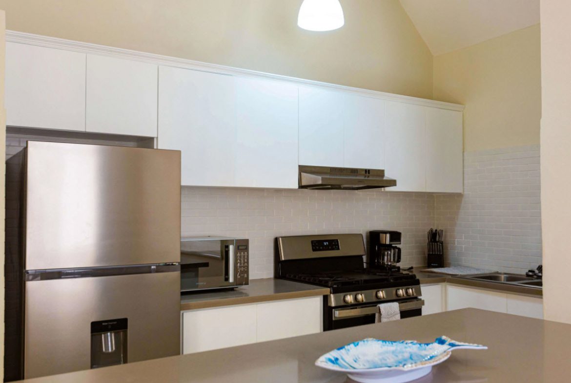 buyDRproperty Modern kitchen in a 3 BR Villa with stainless steel appliances and white cabinets. Sosua Real Estate