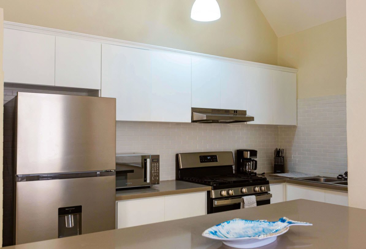 buyDRproperty Modern kitchen in a 3 BR Villa with stainless steel appliances and white cabinets. Sosua Real Estate