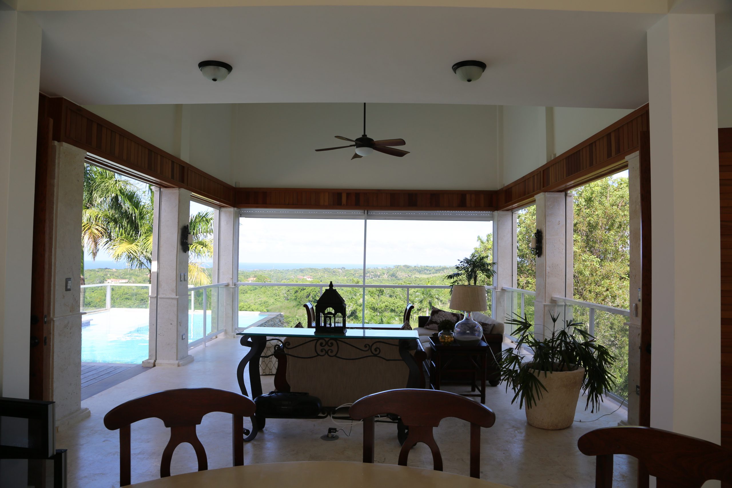 buyDRproperty Spacious living room with pool view and lush greenery Sosua Real Estate