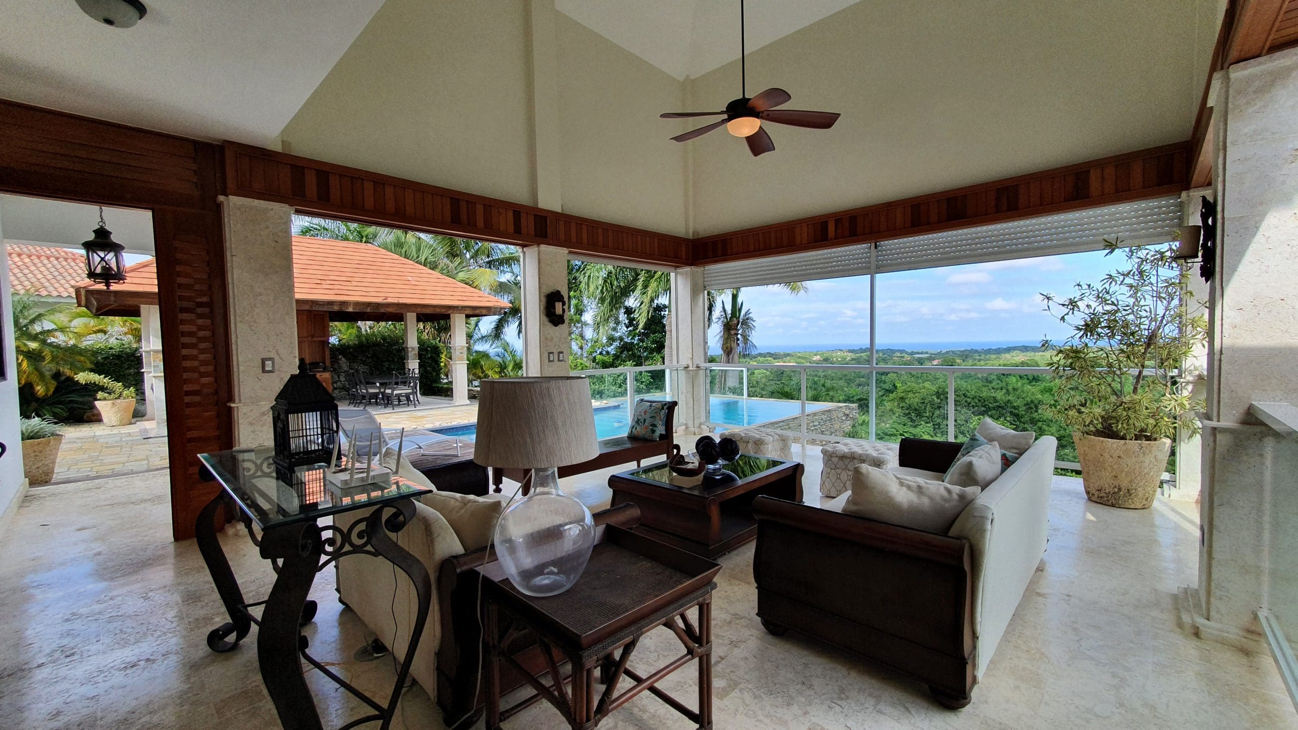 buyDRproperty Luxury home living room with ocean view, pool, and comfortable seating. Sosua Real Estate