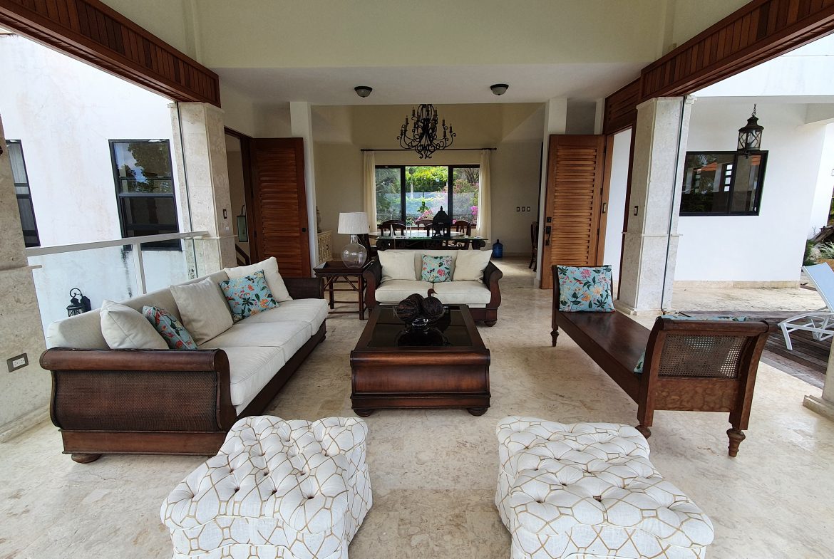 buyDRproperty Luxury outdoor living room with white sofas, wooden furniture, and patio design Sosua Real Estate