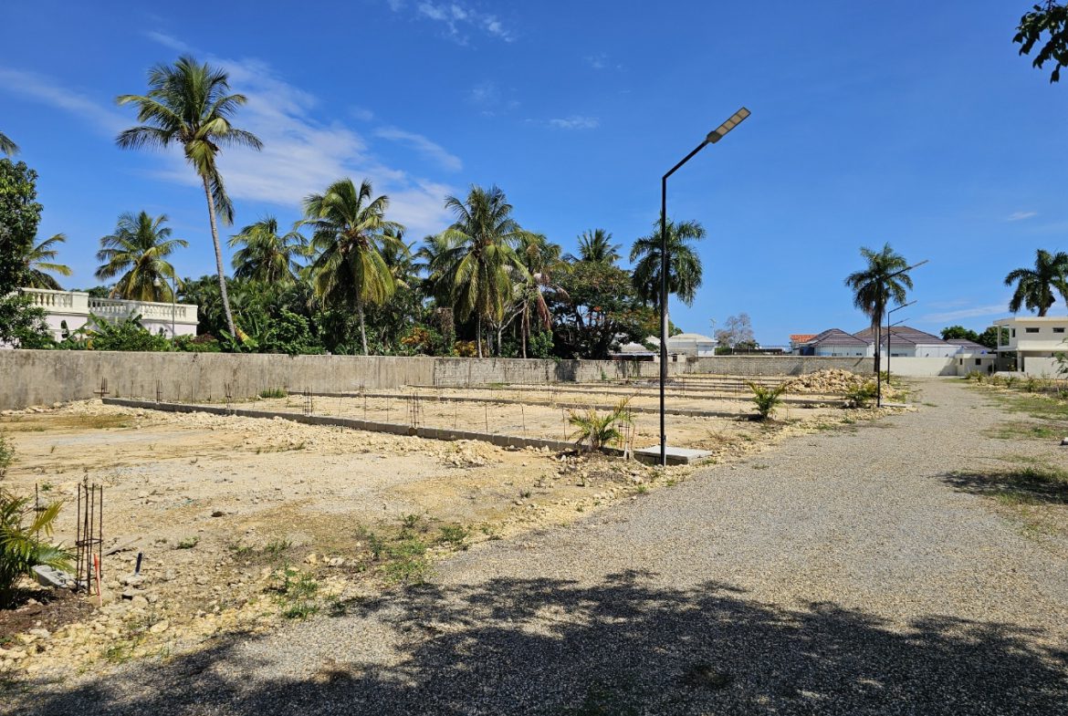 buyDRproperty Construction site with foundations, palm trees, and a blue sky. Sosua Real Estate