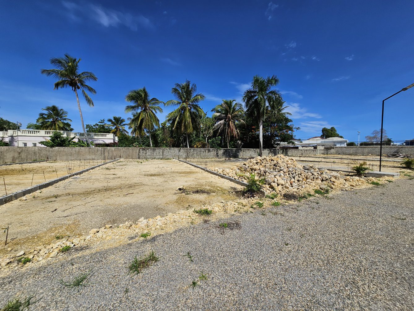 buyDRproperty Cleared building lots with palm trees under a blue sky in a tropical location. Sosua Real Estate