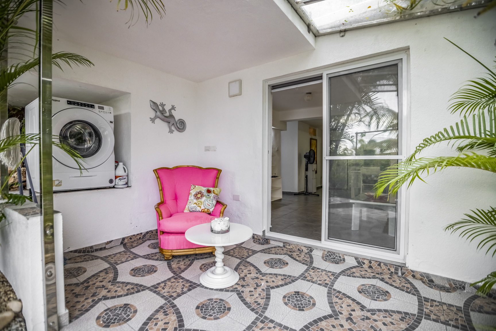 buyDRproperty Cozy patio with pink chair, washing machine, and patterned tile floor. Sosua Real Estate