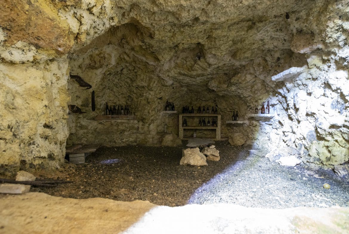 buyDRproperty Wine bottles stored on shelves in a rustic, natural stone cave Sosua Real Estate