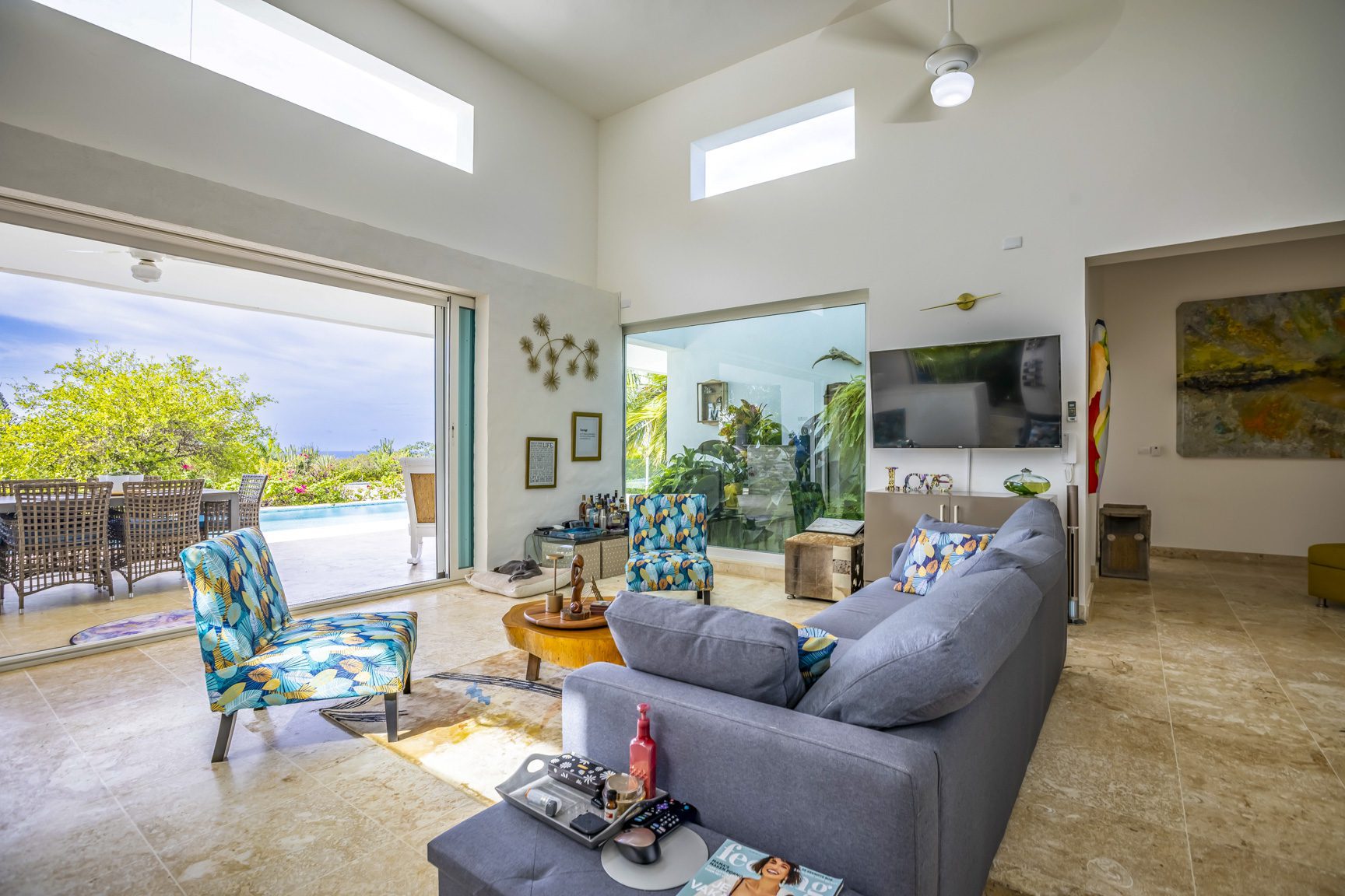 buyDRproperty Spacious living room with gray sofa, open patio view, and modern decor Sosua Real Estate