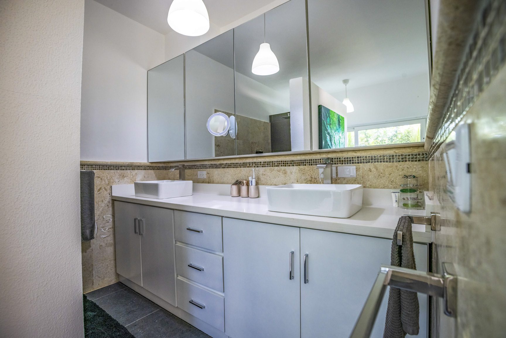 buyDRproperty Modern bathroom with double vanity, white countertop, and large mirror. Sosua Real Estate
