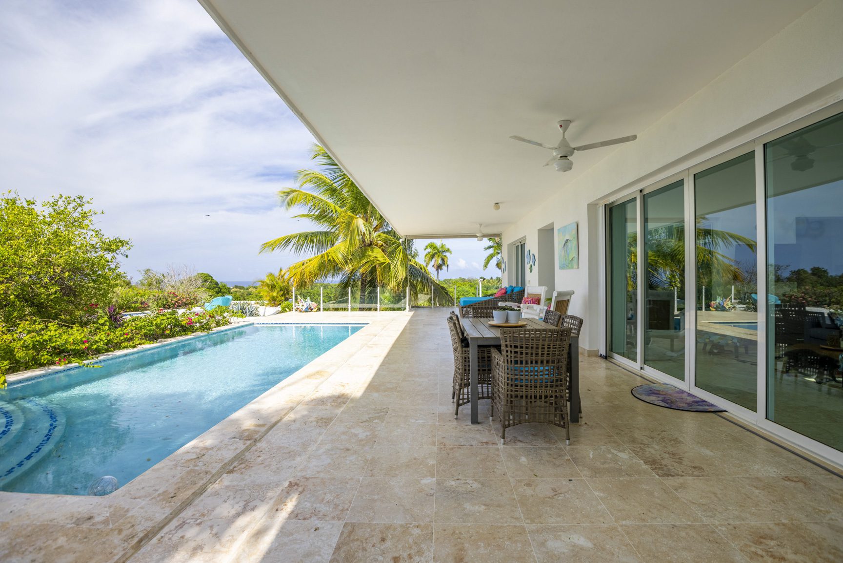 buyDRproperty Spacious patio with dining set and pool overlooking tropical landscape Sosua Real Estate