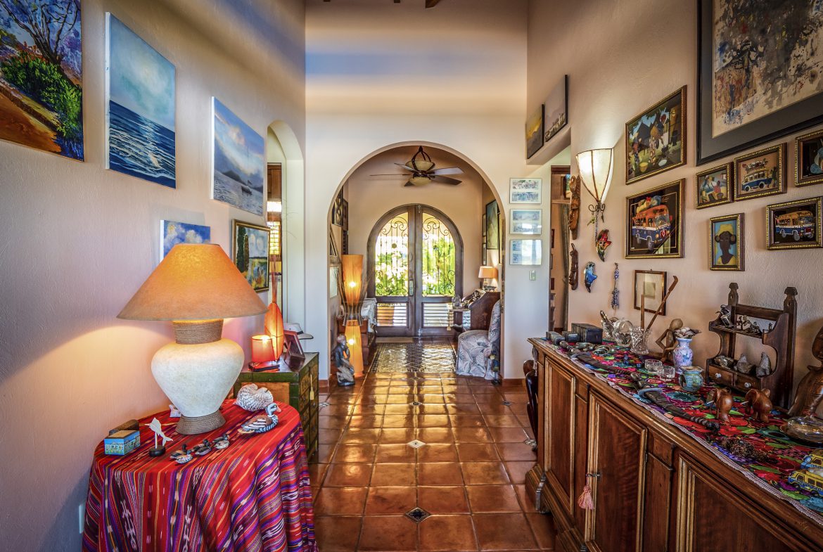 buyDRproperty Colorful art-filled hallway with wooden furniture and warm lighting Sosua Real Estate