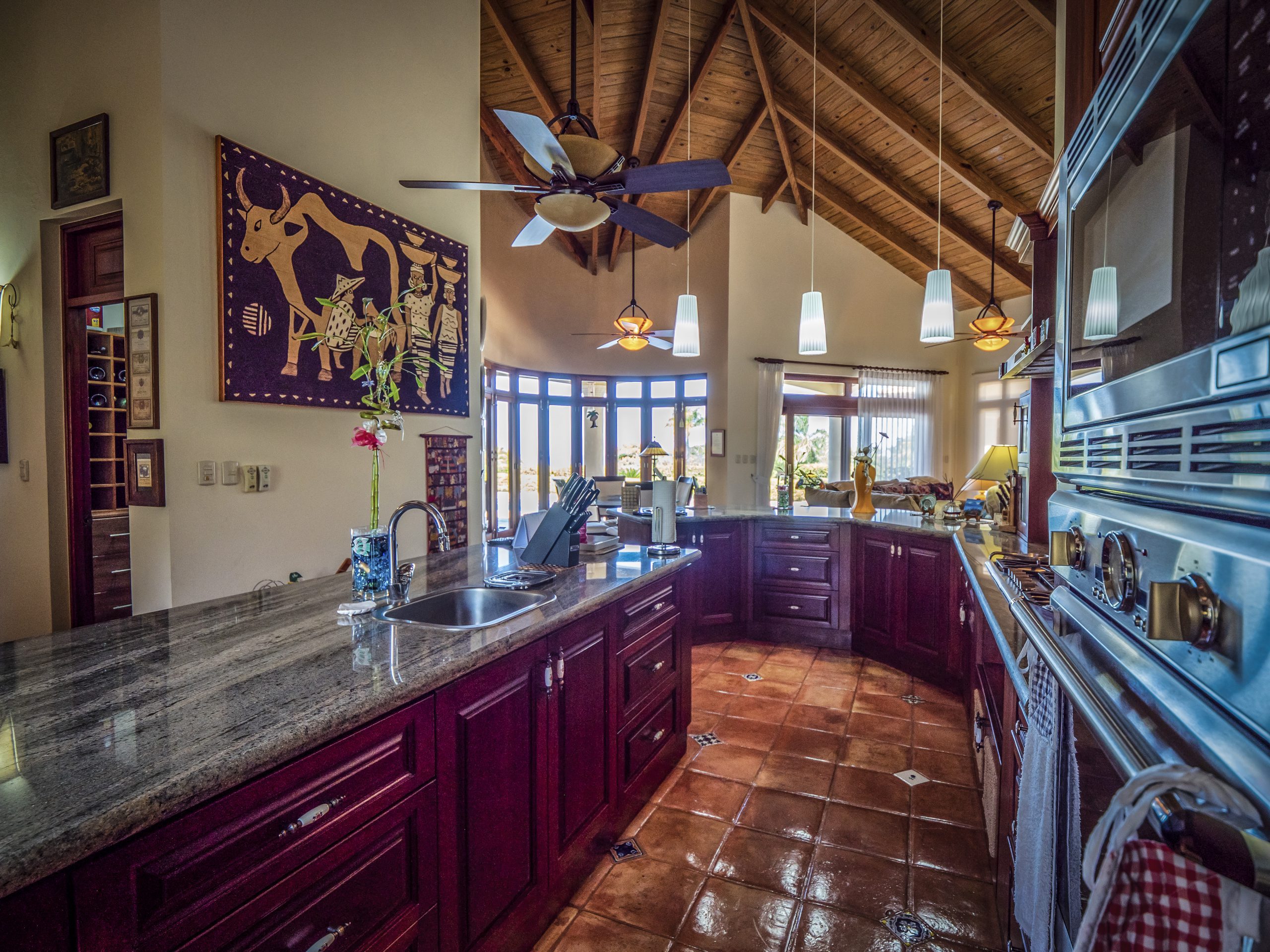 buyDRproperty Rustic kitchen with wooden ceiling, granite countertops, and pendant lights Sosua Real Estate