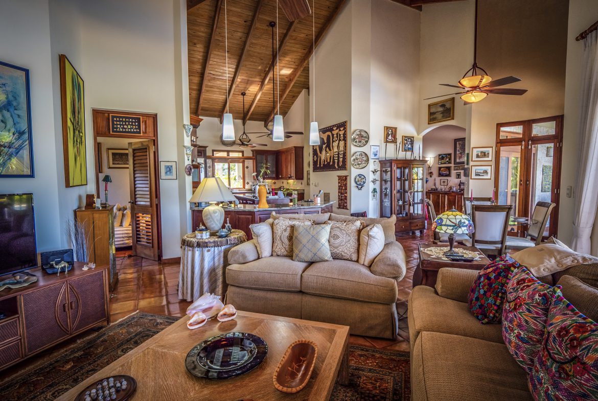 buyDRproperty Spacious living room with high wooden ceiling and cozy seating area Sosua Real Estate
