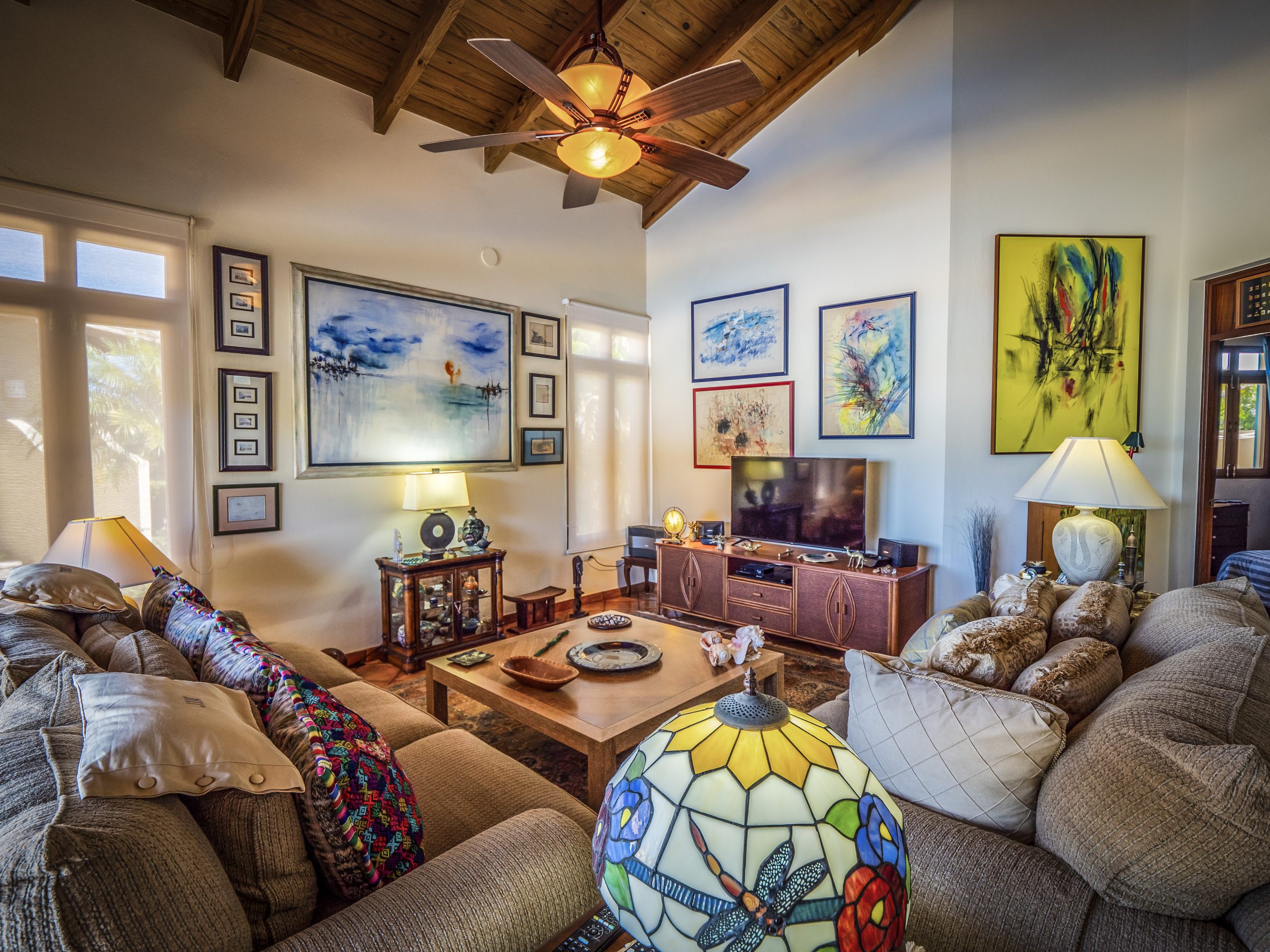 buyDRproperty Cozy living room with colorful art and ceiling fan Sosua Real Estate