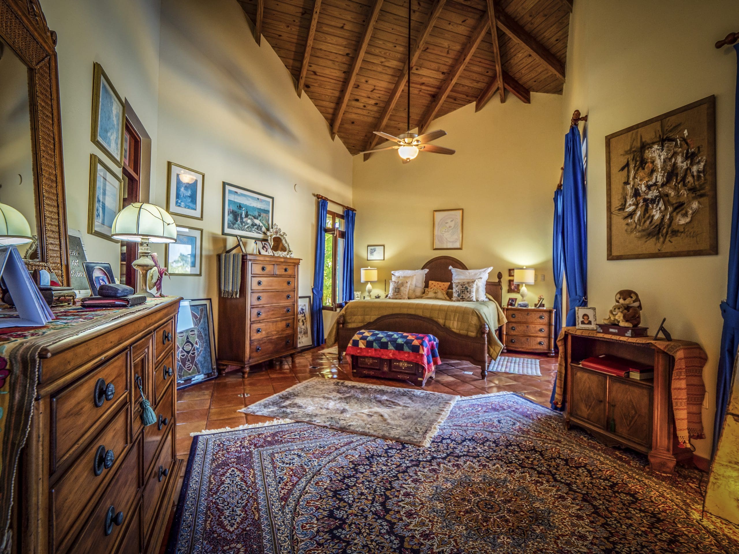 buyDRproperty Cozy bedroom with high ceiling, ornate rugs, wood furniture, and warm lighting Sosua Real Estate