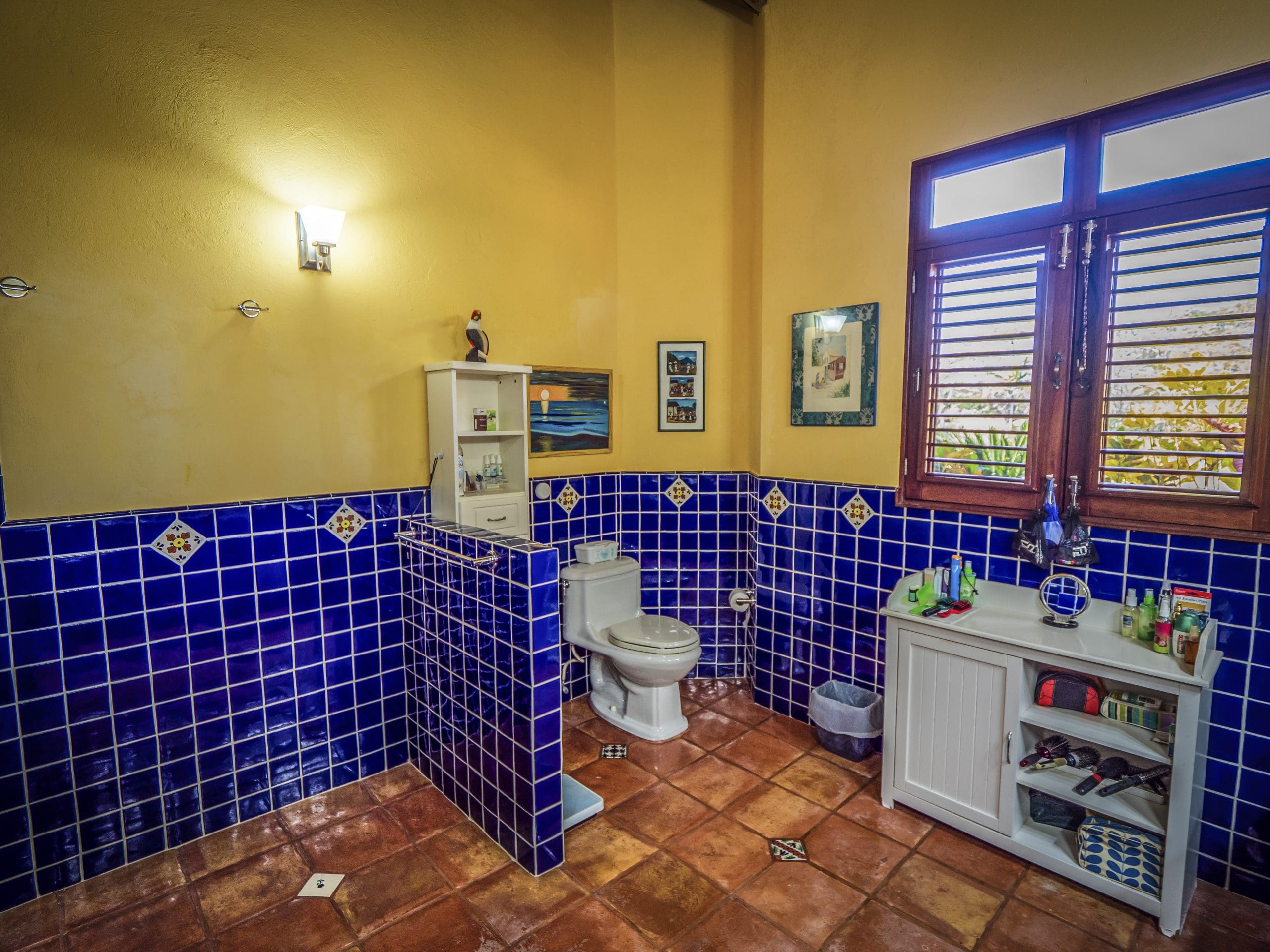 buyDRproperty Colorful bathroom with blue tile walls and natural light from the window Sosua Real Estate