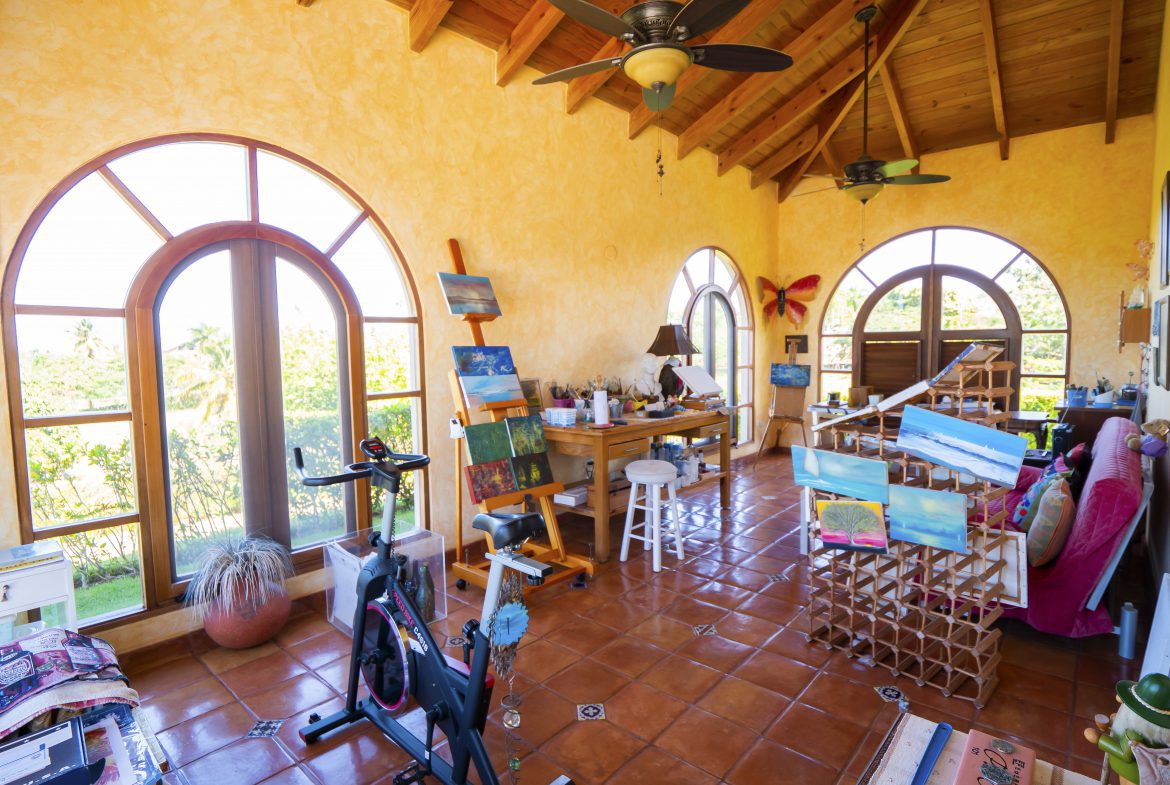 buyDRproperty Bright art studio with easels, exercise bike, and large arched windows Sosua Real Estate