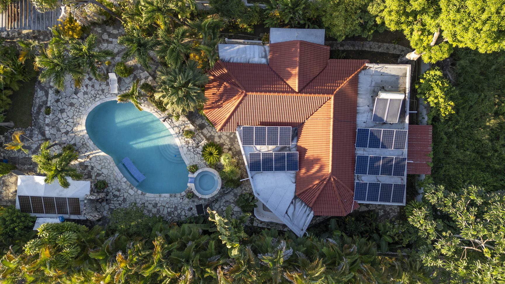 buyDRproperty Aerial view of modern villa in Perla Marina with pool, solar panels, and lush landscaping. Sosua Real Estate