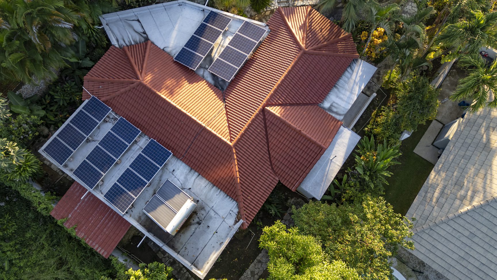 buyDRproperty Aerial view of a modern villa with red roof tiles and solar panels in Perla Marina. Sosua Real Estate