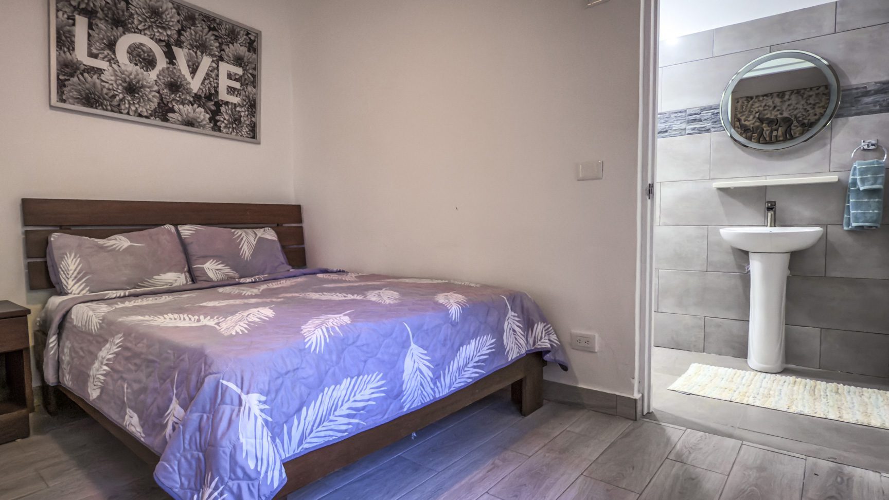 buyDRproperty Bedroom with LOVE art and ensuite bathroom. Sosua Real Estate