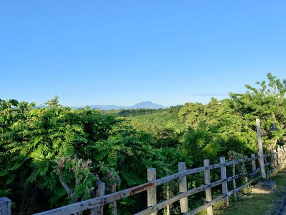 buyDRproperty Lush green landscape with distant mountains, viewed from Panorama Village. Ocean-view lot available. Sosua Real Estate