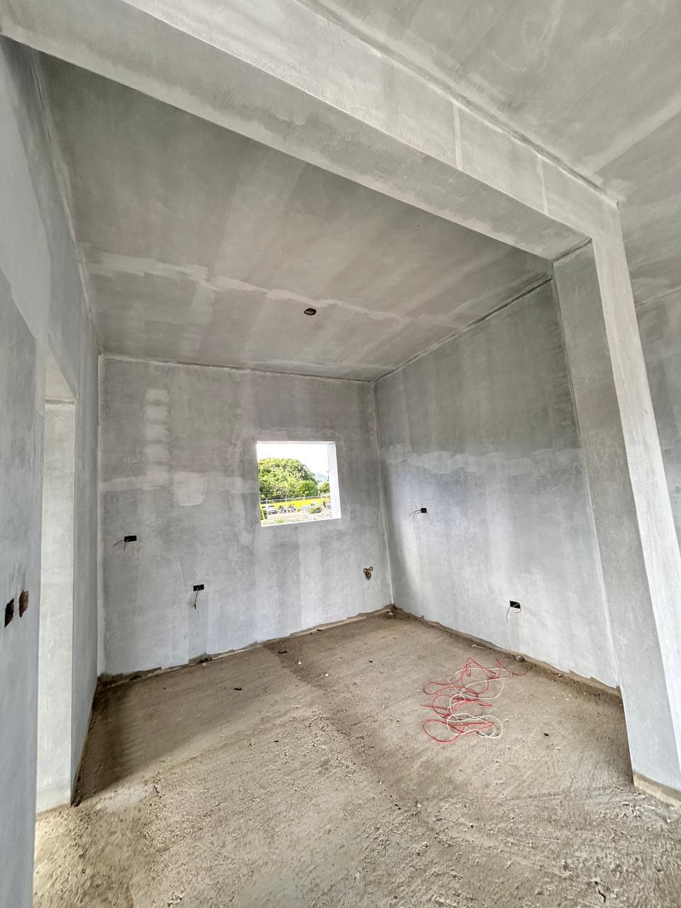 buyDRproperty Unfinished room with concrete walls and floor, small window showing greenery outside Sosua Real Estate