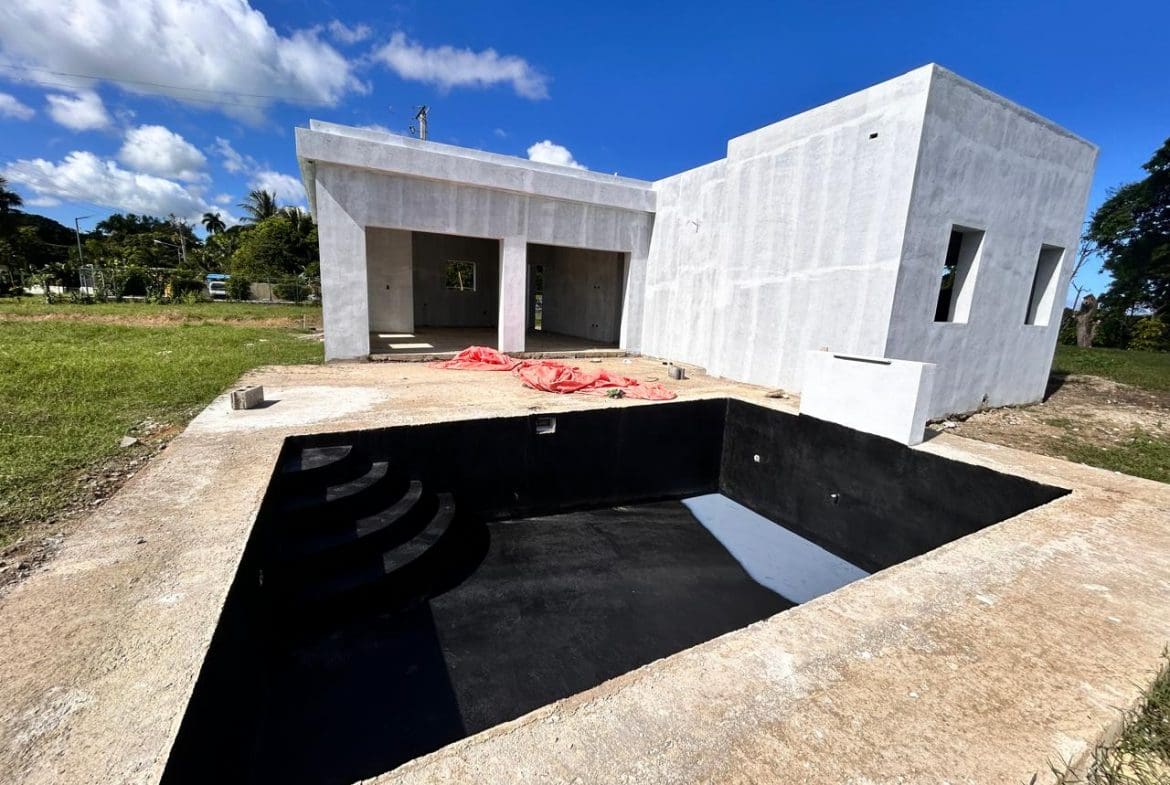 buyDRproperty Unfinished modern house with empty swimming pool under sunny sky. Future home. Sosua Real Estate