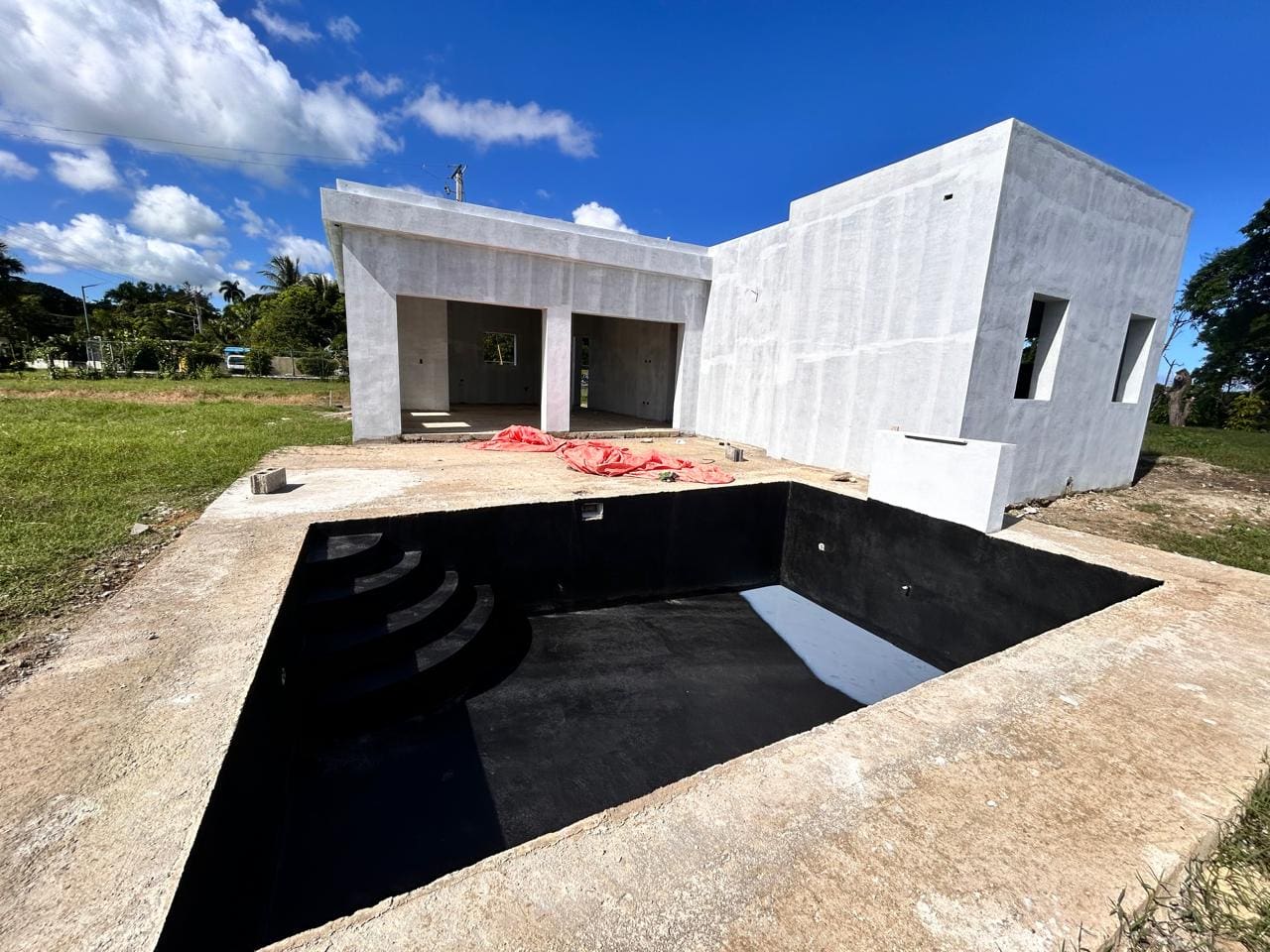 buyDRproperty Unfinished modern house with empty swimming pool under sunny sky. Future home. Sosua Real Estate