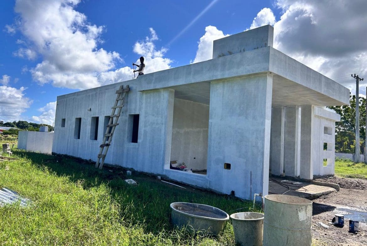 buyDRproperty Unfinished modern house under construction with a worker on the roof and a ladder. Sosua Real Estate