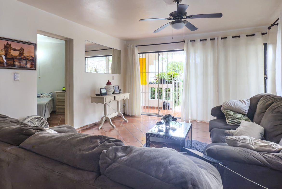 buyDRproperty Living room in Sosúa condo for sale, leading to playa balcony. Sosua Real Estate
