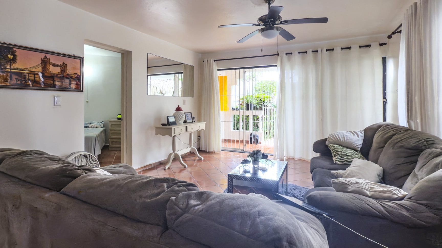 buyDRproperty Living room in Sosúa condo for sale, leading to playa balcony. Sosua Real Estate