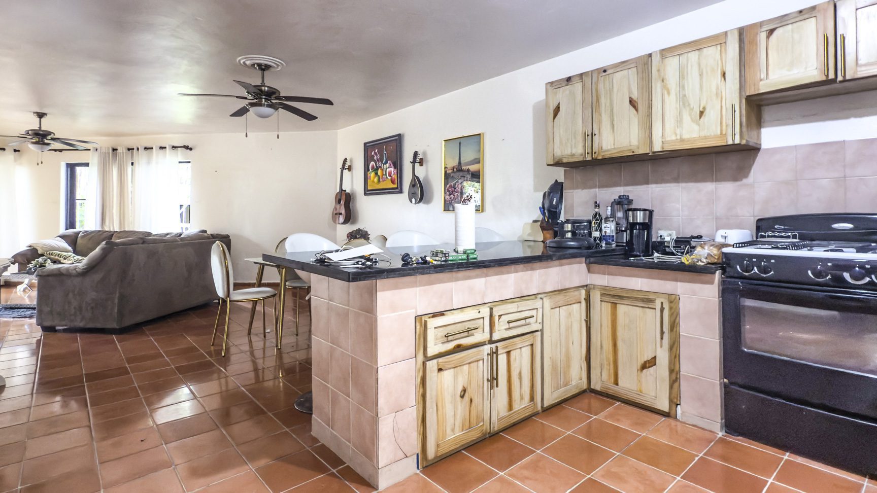 buyDRproperty Open concept kitchen and living area in Sosúa home for sale, featuring tile flooring and wood cabinetry. Sosua Real Estate