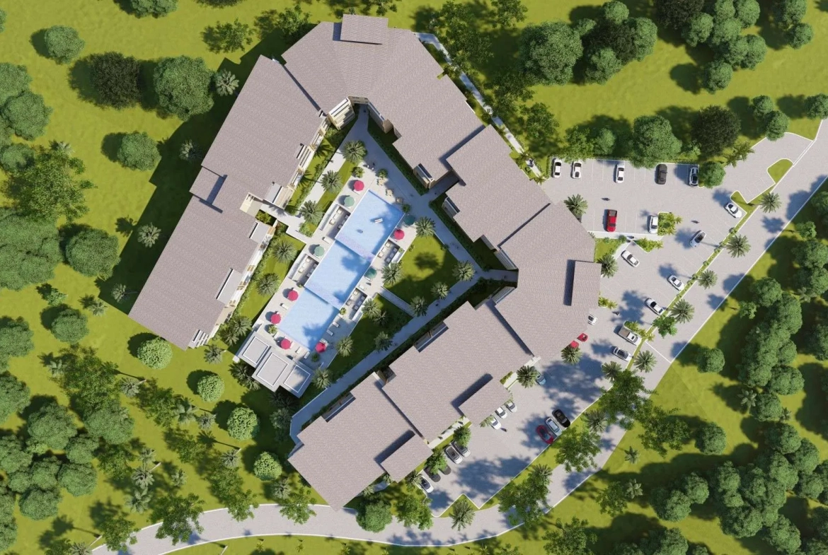 buyDRproperty Aerial view of a resort with a central pool, surrounding buildings, parking area, and lush green landscaping. Sosua Real Estate