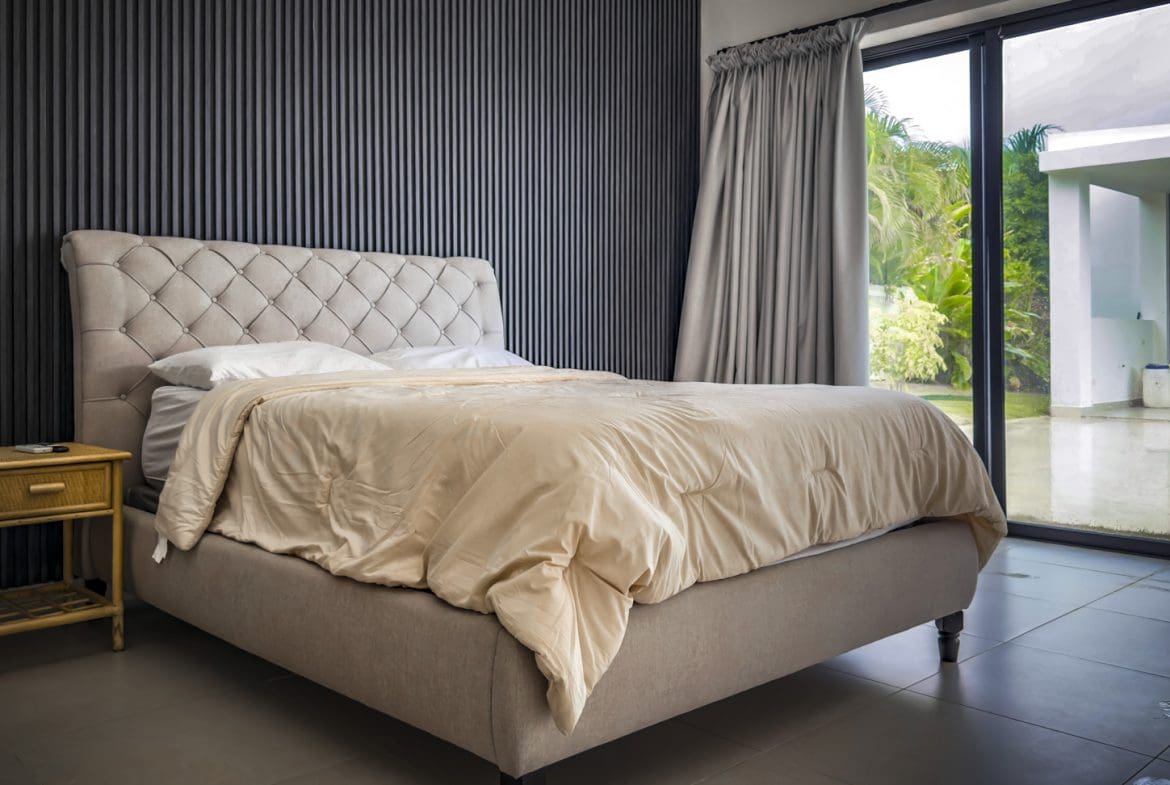 buyDRproperty Luxury bedroom with a tufted headboard in a Sosua Ocean Village villa for sale. Sosua Real Estate