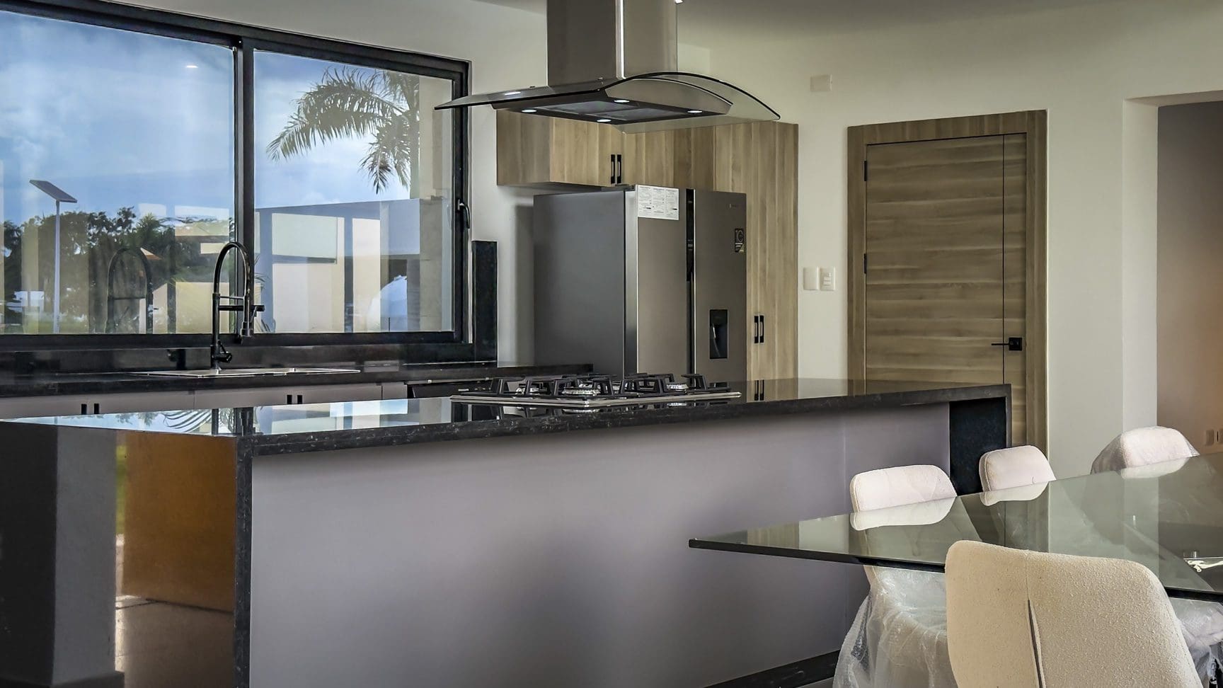 buyDRproperty Modern kitchen in a luxury villa with stainless steel appliances and a dark countertop. Sosua Real Estate