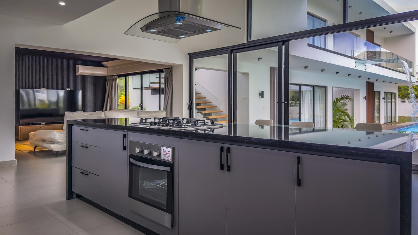 buyDRproperty Luxury villa kitchen with black countertops and stainless steel appliances in Sosua Ocean Village. Sosua Real Estate